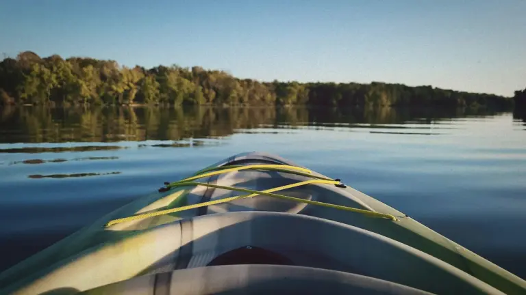 A quiet lake stretching toward a sunlit horizon